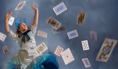 Alice in wonderland surrounded by playing cards