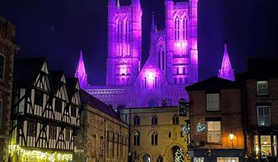 A view of Lincoln Cathedral from Castle Square, illuminated purple for Christmas