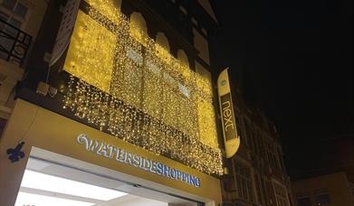 Waterside shopping centre at night time with fairy lights
