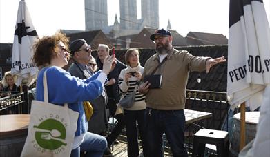 A tour party hearing about the history of food in Lincoln at the first stop of the tour