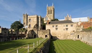 Medieval Bishops' Palace in Lincoln with Lincoln Cathedral in background and freshly mowed grass in foreground.